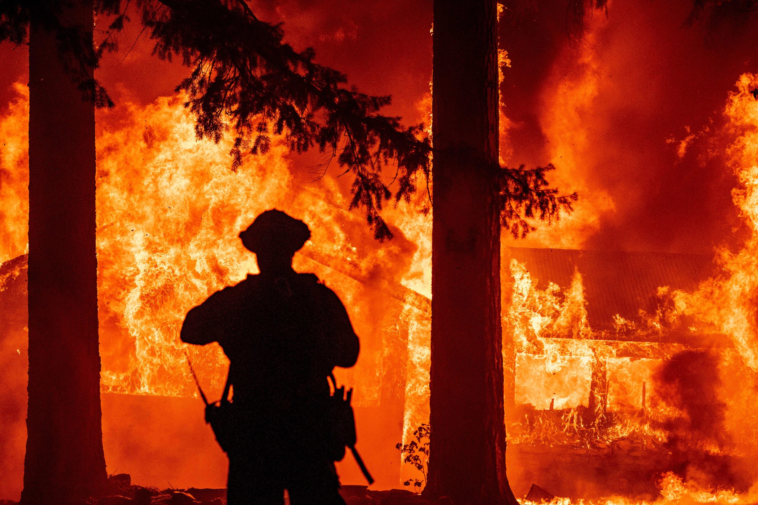 Firefighters try to get control of the scene as the Dixie fire burns dozens of homes in the Indian Falls neighborhood of unincorporated Plumas County, California on July 24, 2021. - The Dixie fire, which started only a few miles from the origin of the deadly Camp fire, has churned through more than 185,000 acres and continues to burn towards rural communities. (Photo by JOSH EDELSON / AFP)